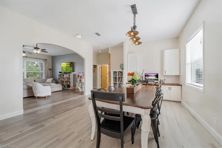 Dining space with visible vents, baseboards, light wood finished floors, and a healthy amount of sunlight