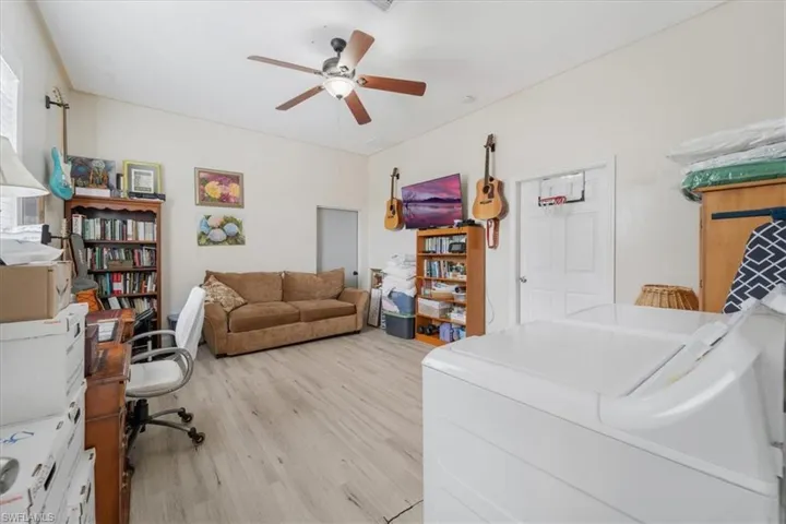 Office featuring washer / clothes dryer, light wood-type flooring, and a ceiling fan