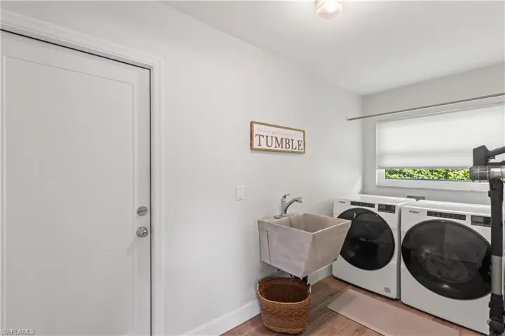 Washroom with light wood-type flooring and separate washer and dryer