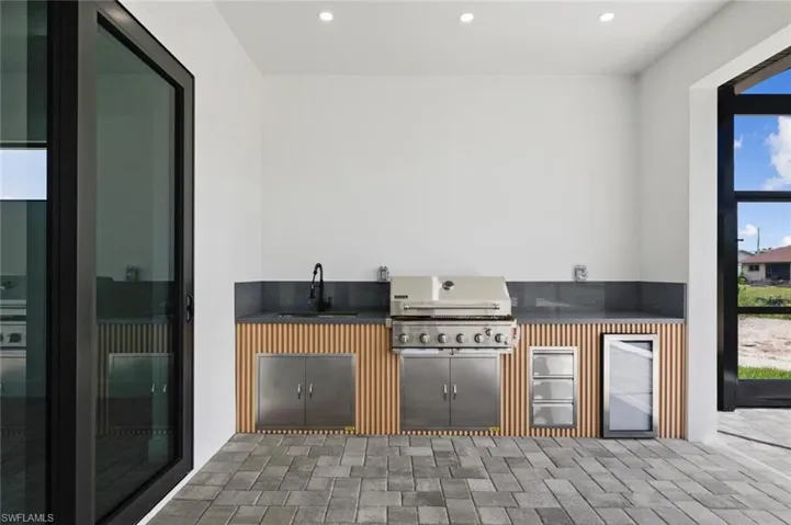 View of patio featuring sink, a grill, and exterior kitchen