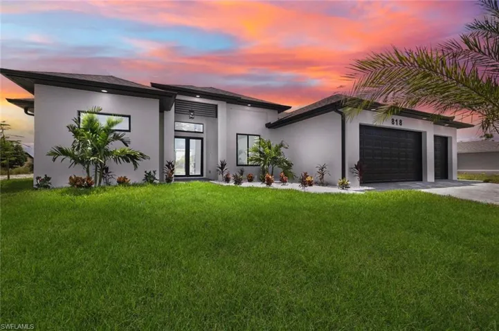 Modern home featuring a lawn and a garage
