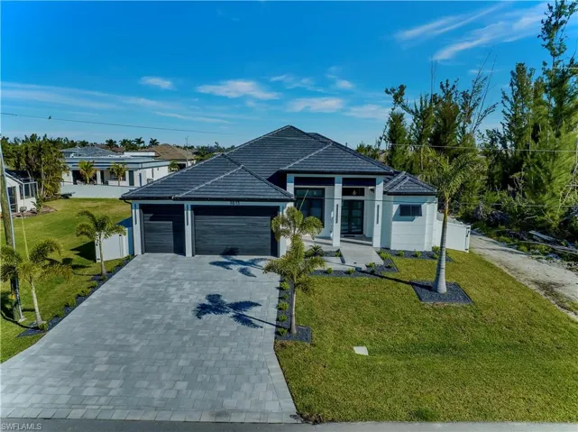 Single story home with a garage, a front lawn, fence, and decorative driveway