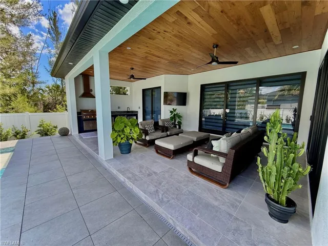 View of patio featuring area for grilling, a ceiling fan, an outdoor hangout area, and fence