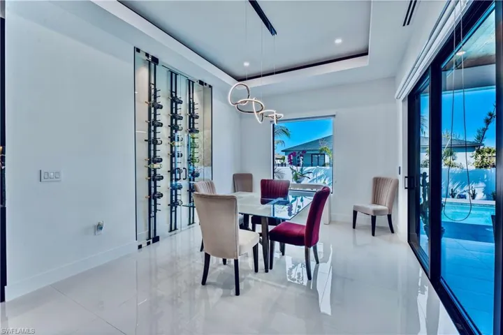Dining area featuring baseboards, plenty of natural light, recessed lighting, and a raised ceiling
