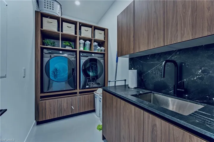 Laundry room featuring washer and dryer, laundry area, a sink, and light tile patterned floors