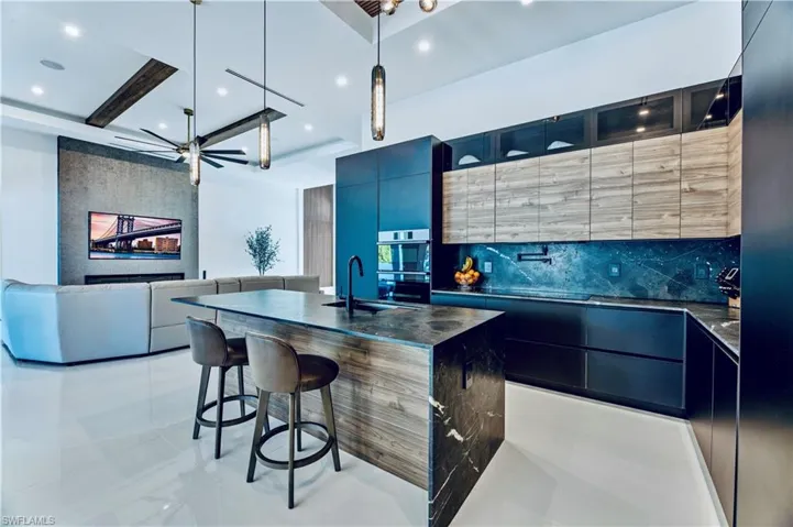 Kitchen with a kitchen breakfast bar, a sink, modern cabinets, and decorative backsplash