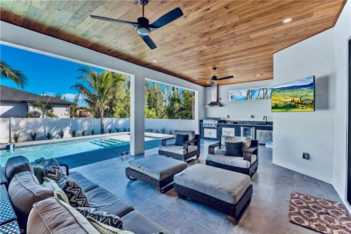 View of patio / terrace with a fenced backyard, grilling area, an outdoor living space, a sink, and an outdoor kitchen