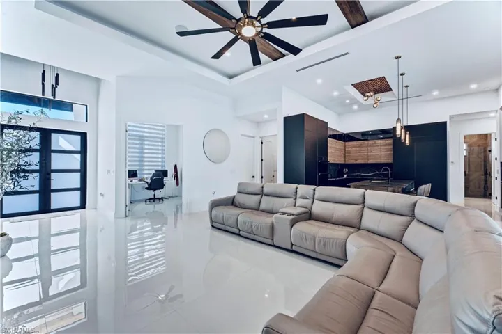 Living area with a ceiling fan, recessed lighting, a tray ceiling, and visible vents