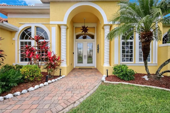 Lush landscaping creates an inviting entry to this beautiful home.