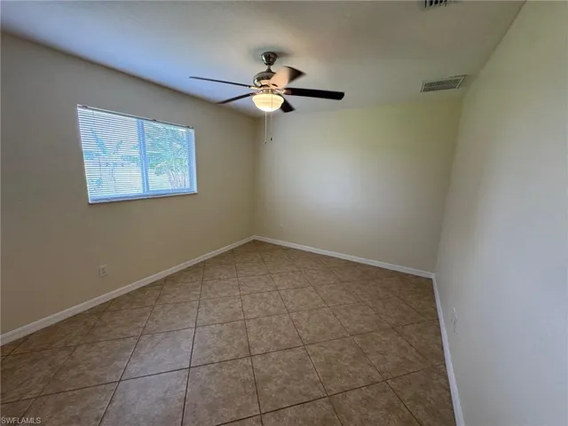 Guest bedroom 2 featuring light tile patterned flooring and a ceiling fan