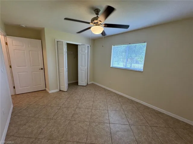 Guest bedroom 2featuring a closet, ceiling fan, and light tile patterned flooring