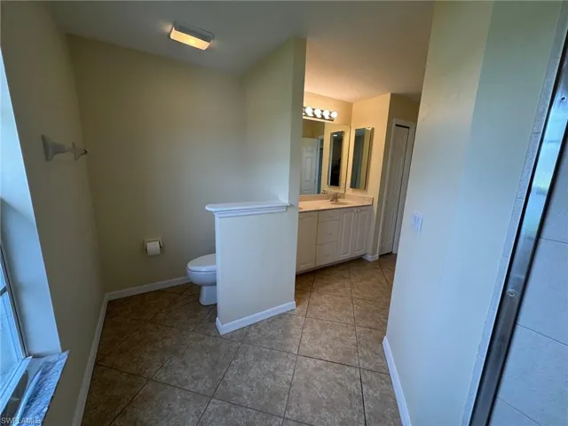 Primary bathroom with vanity and light tile patterned flooring