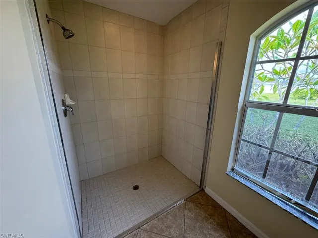 Primary bathroom with a handicap accessible shower and tile patterned flooring