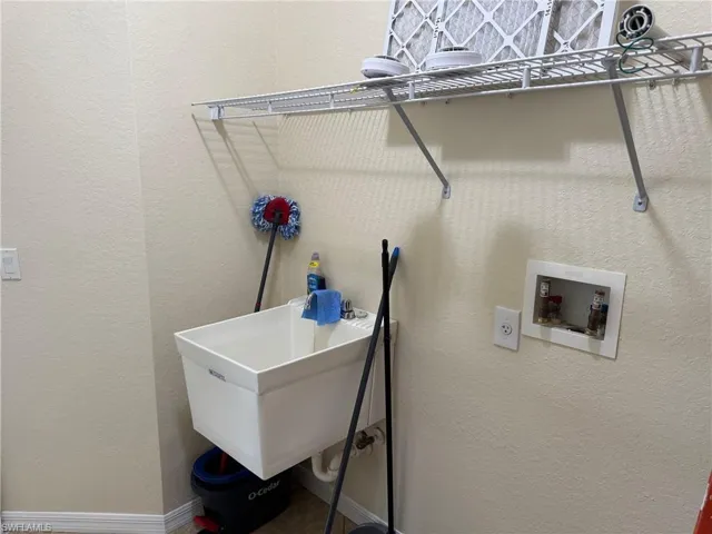 Laundry area featuring a textured wall and hookup for a washing machine