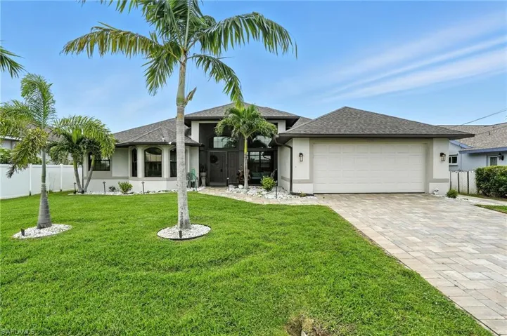 Single story home featuring a shingled roof, stucco siding, a garage, and decorative driveway