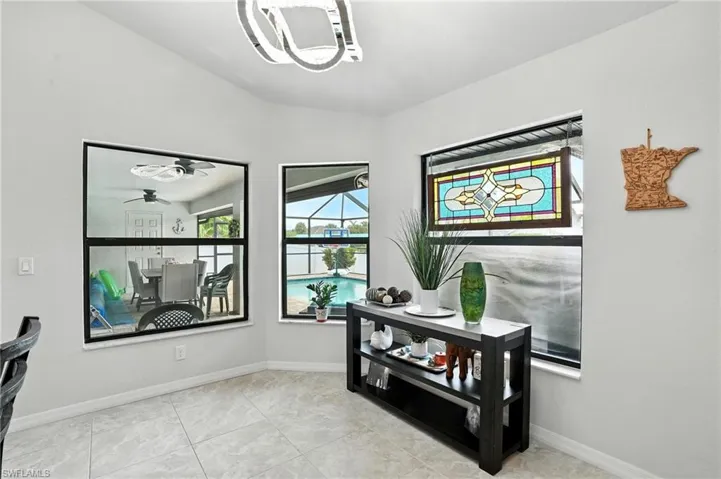 Carpeted bedroom with multiple windows, access to outside, a raised ceiling, and ceiling fan