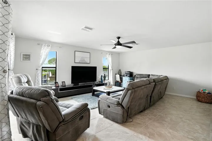 Carpeted bedroom with access to outside, a raised ceiling, and ceiling fan