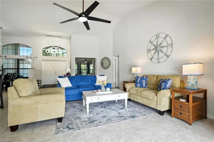 Kitchen featuring light countertops, ceiling fan, high vaulted ceiling, open floor plan, and a kitchen island