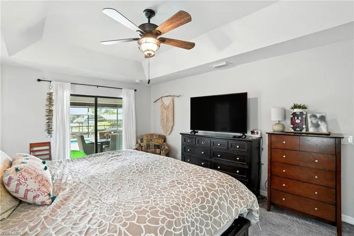 Bedroom featuring carpet flooring, ceiling fan, and an office area