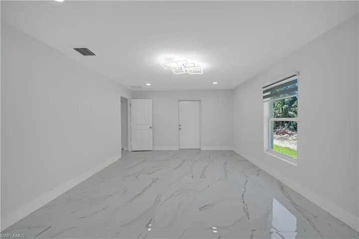 Empty room featuring baseboards, marble finish floor, and visible vents