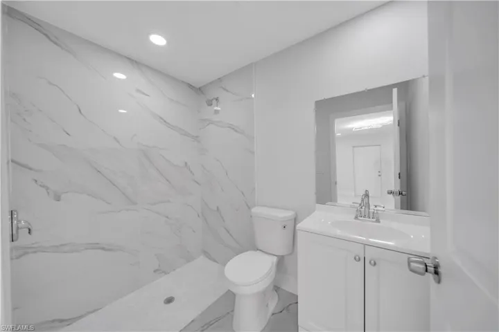 Full bathroom with marble finish floor, toilet, vanity, and a marble finish shower
