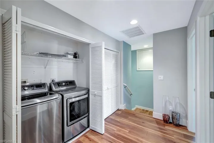 Laundry area featuring washing machine and dryer, light wood finished floors, and recessed lighting