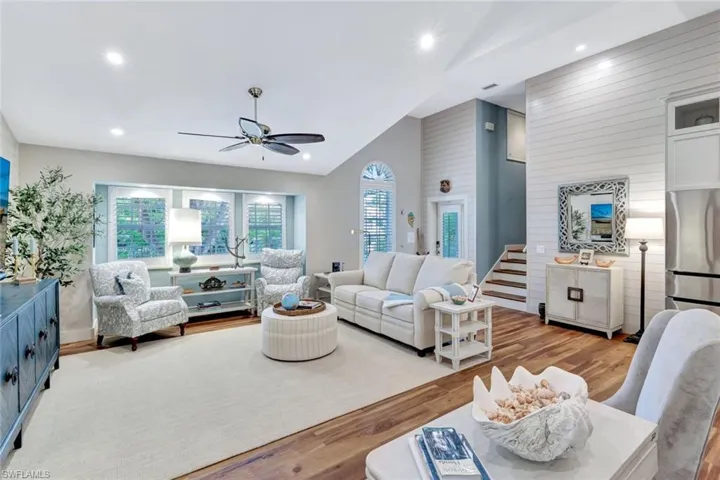 Living room featuring a ceiling fan, light wood-type flooring, vaulted ceiling, and recessed lighting