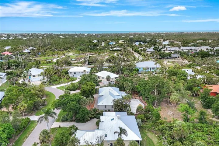 Aerial view of property's location with nearby suburban area and a tree filled landscape