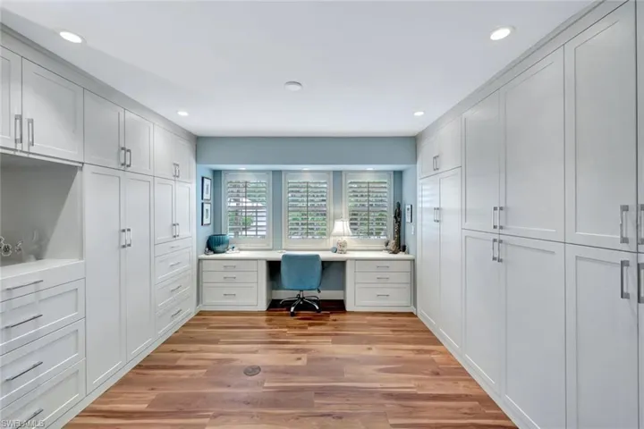 Home office featuring built in desk, light wood-style floors, and recessed lighting