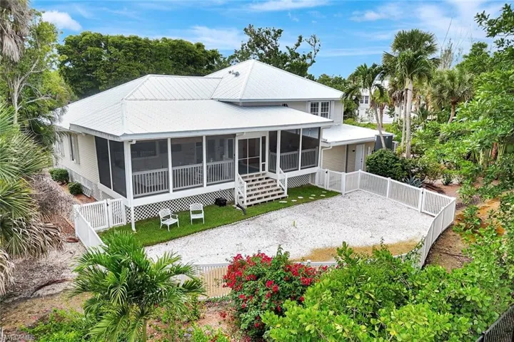 Back of house with a sunroom, a fenced backyard, driveway, and a gate
