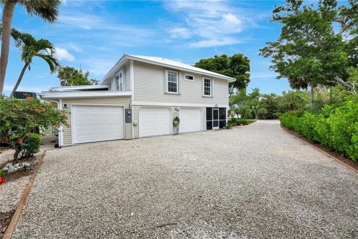 View of side of home featuring gravel driveway and a garage
