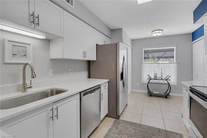 Remodeled with quartz countertops; doors to the left are to the pantry while doors to the right are to the washer and dryer