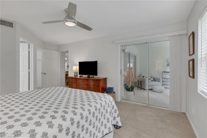 Door to the left leads to the primary bathroom; door just past the bathroom is the walk-in closet; slider doors lead to the enclosed sitting area