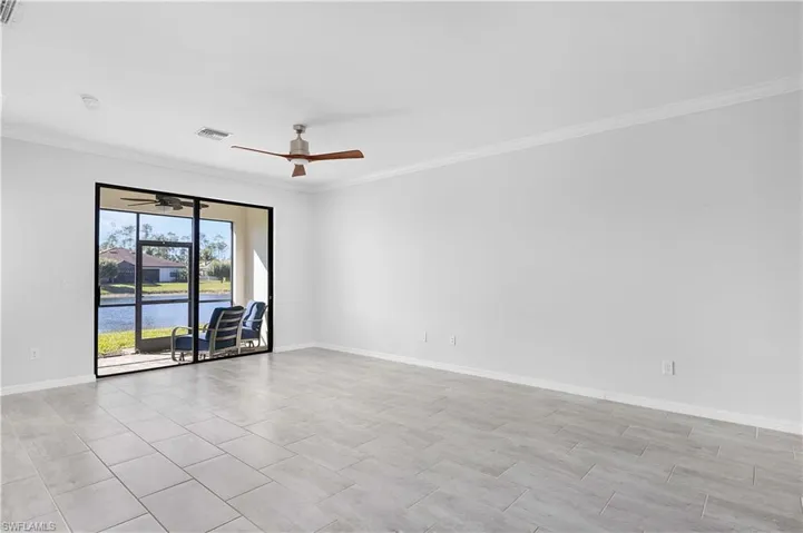 Unfurnished room with crown molding, ceiling fan, and a water view