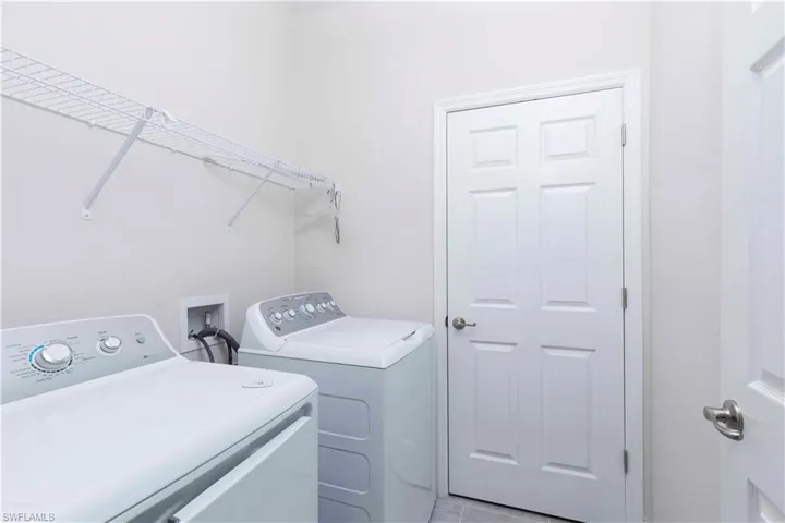 Washroom featuring separate washer and dryer and light tile patterned floors