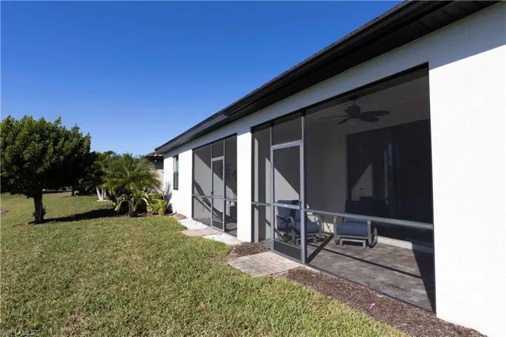 View of yard featuring a sunroom, ceiling fan, and a patio area
