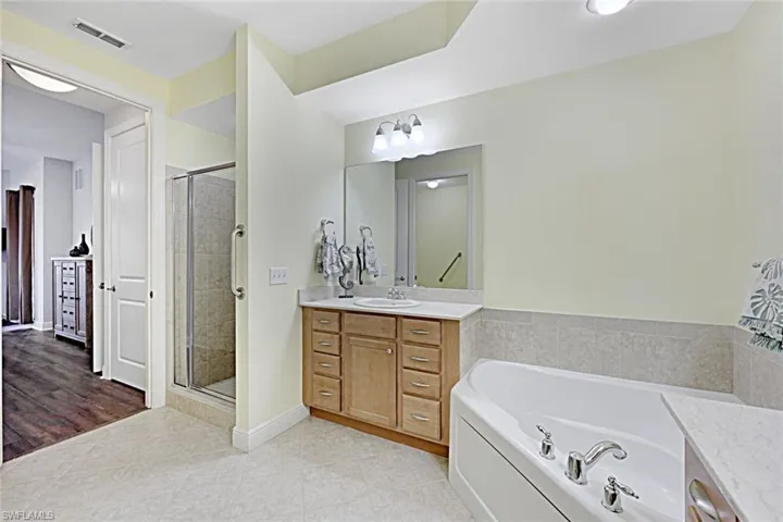 Bathroom with vanity, a bath, light tile patterned floors, and a stall shower