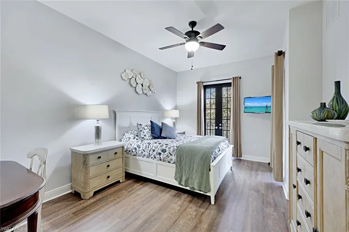 Bedroom featuring light wood-style flooring, a ceiling fan, and french doors