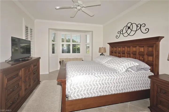 Primary bedroom featuring crown molding and ceiling fan
