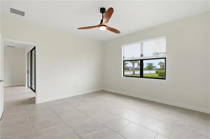 Bright interior space featuring light-toned tile flooring and a ceiling fan with integrated lighting
