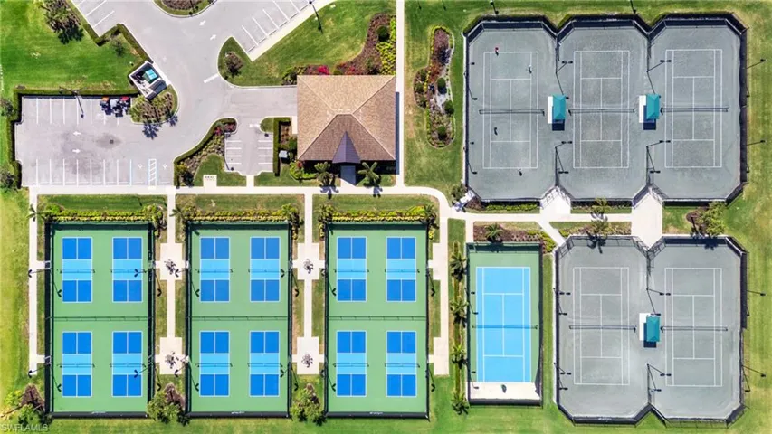 Comprehensive recreational facility featuring multiple tennis courts, pickleball courts, and a central clubhouse with ample parking