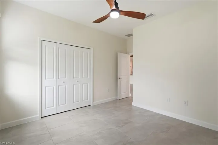 Neutral-toned interior room featuring light gray tile flooring and white baseboards