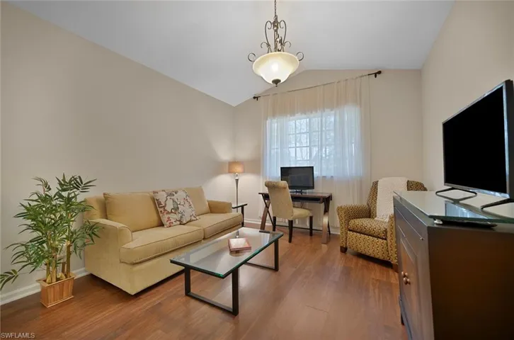 Living area with lofted ceiling and wood finished floors
