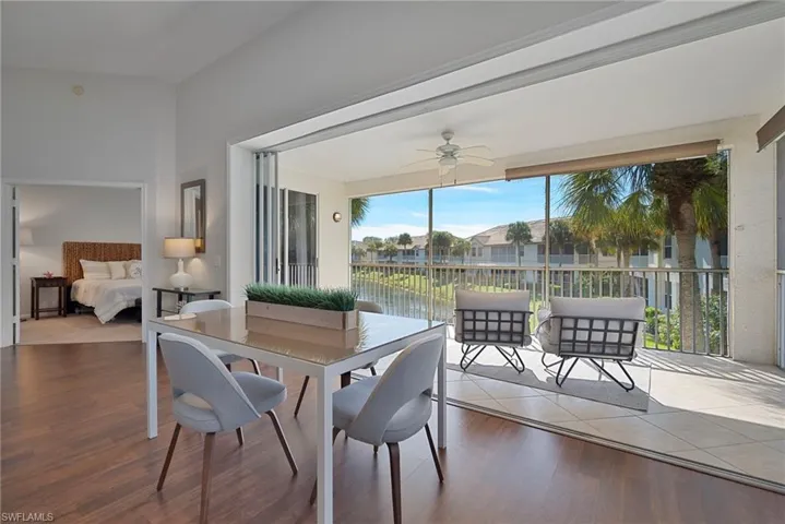 Sunroom / solarium with wood finished floors, a water view, and a residential view