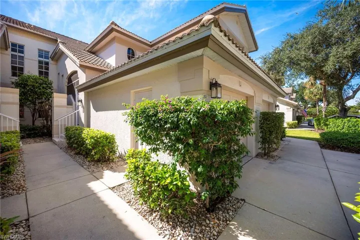 View of side of property with stucco siding and a tiled roof