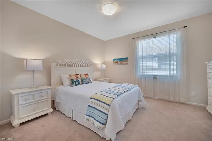 Bedroom with baseboards and light carpet