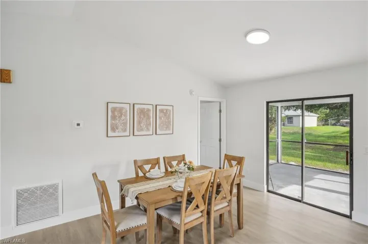Dining area featuring vaulted ceiling, light wood-type flooring, and baseboards