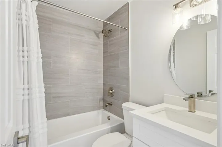 Full bathroom with shower / bath combination with curtain, toilet, and vanity