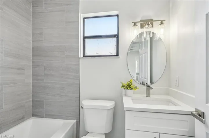 Bathroom with vanity, toilet, and washtub / shower combination
