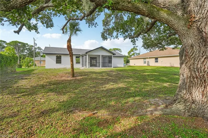 Back of property featuring a sunroom and a yard